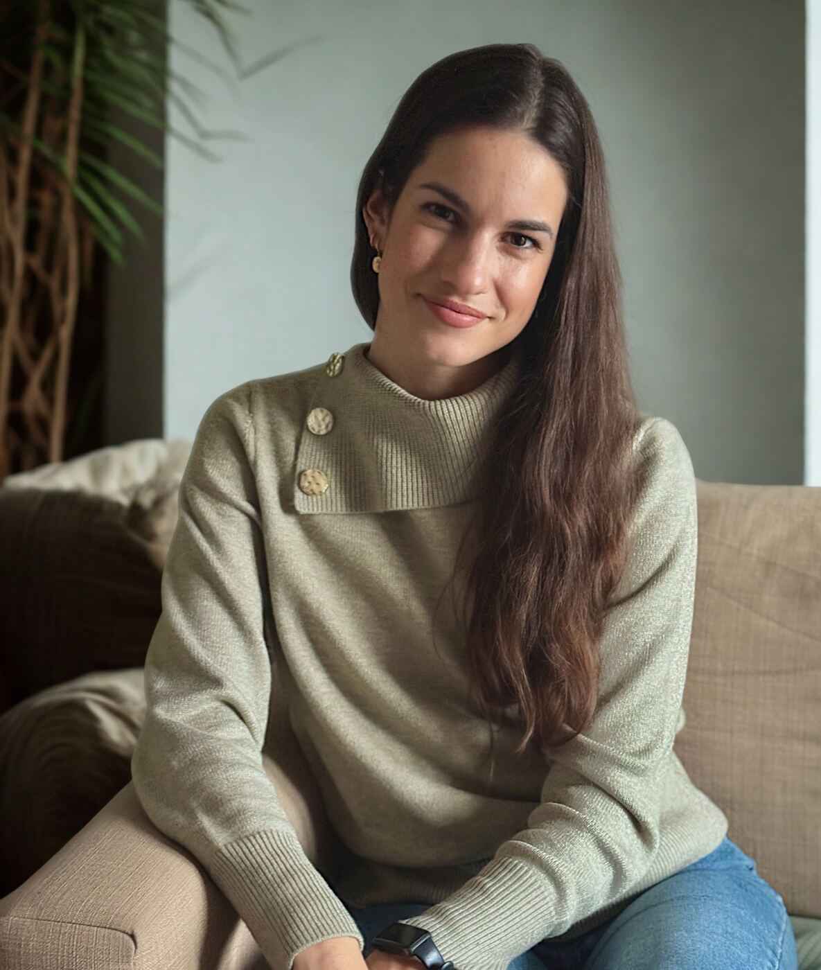 Retrato de Alicia León en un sofá, con jersey verde salvia
